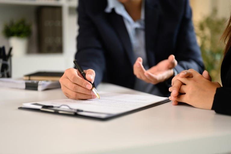 Two businesspeople in suits finalizing an important business deal at a modern office desk